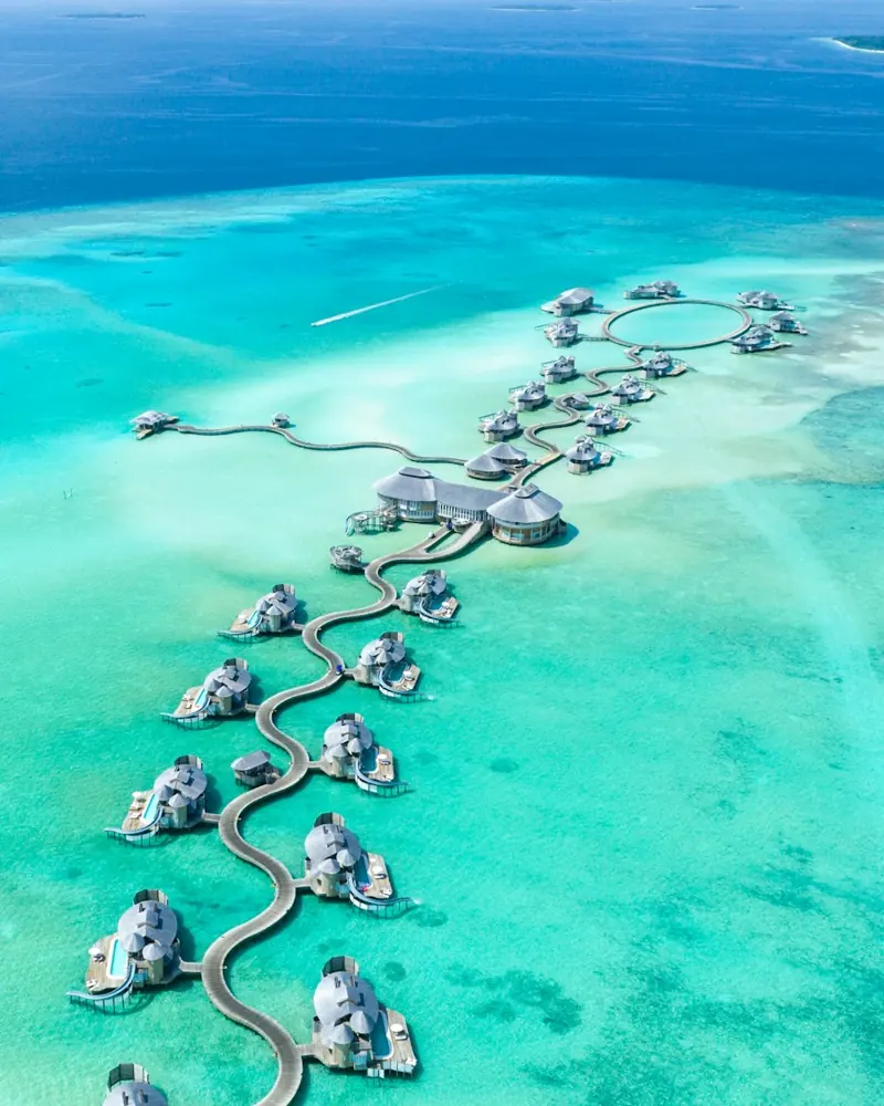 Overwater villas beside a turquoise lagoon